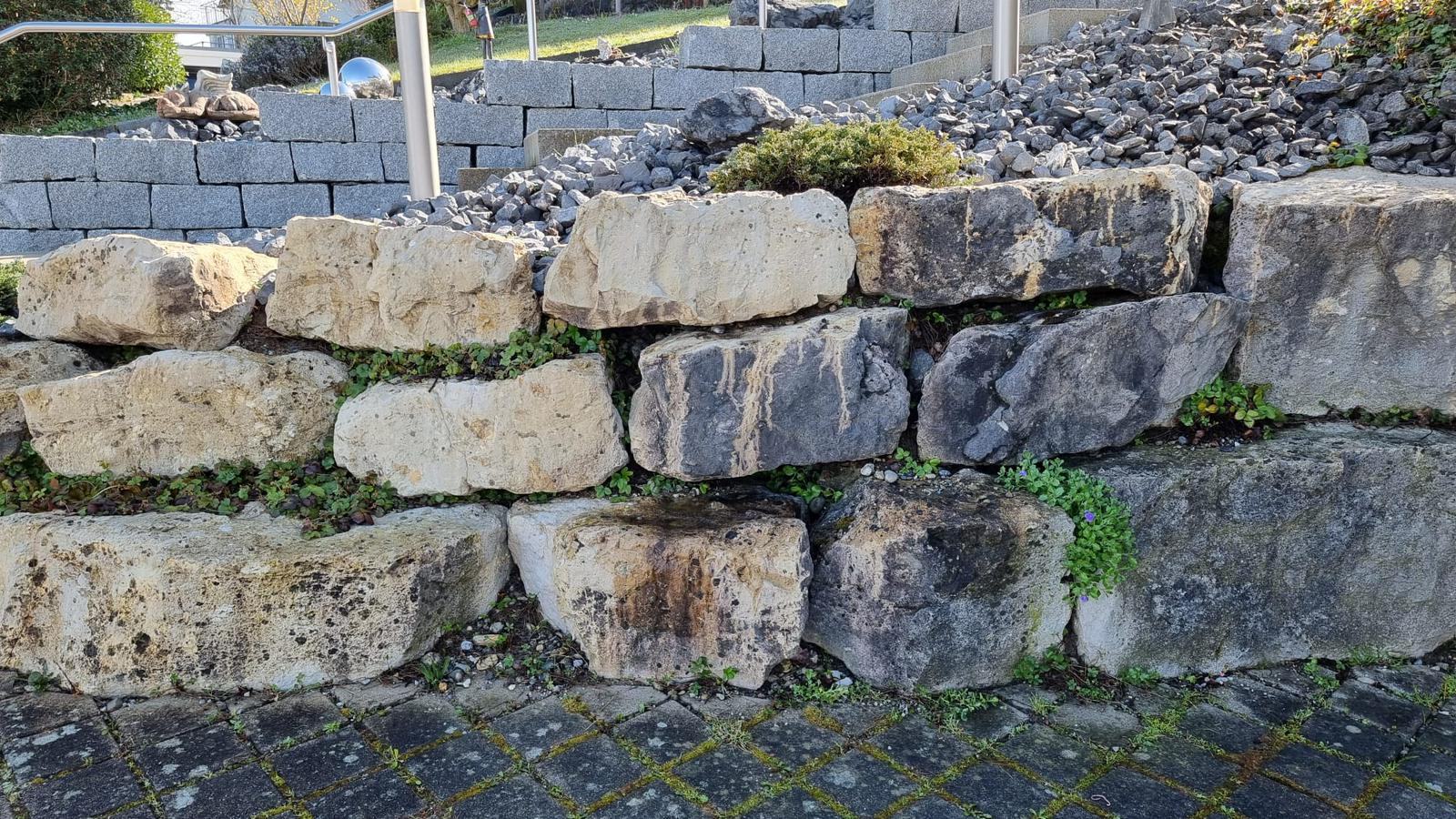 Trockenmauer aus Kalkstein über einem Kiesbeet